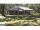 A lovely backyard view featuring a house with a sunroom, lush greenery, and mature trees providing ample shade at 3930 Griffin Ave, Lady Lake, FL 32159