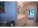 Well-lit bathroom featuring a white vanity, decorative accents, and a peek into the home, creating a clean and functional space at 3930 Griffin Ave, Lady Lake, FL 32159