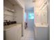 Bright bathroom adjacent to laundry area featuring a vanity, tile flooring, and built-in shelving, providing convenience and functionality at 3930 Griffin Ave, Lady Lake, FL 32159