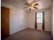 Cozy bedroom featuring neutral carpet, a ceiling fan, and a window with curtains, offering a comfortable and inviting space at 3930 Griffin Ave, Lady Lake, FL 32159