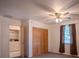 Comfortable bedroom featuring neutral carpet, a ceiling fan, a closet, and a laundry room at 3930 Griffin Ave, Lady Lake, FL 32159