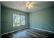 Bright bedroom features wood floors, a ceiling fan, and a large window with scenic views at 3930 Griffin Ave, Lady Lake, FL 32159