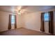 Comfortable bedroom featuring neutral carpet, a ceiling fan, and dual windows dressed with curtains, letting in plenty of natural light at 3930 Griffin Ave, Lady Lake, FL 32159