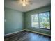 Bright bedroom features wood floors, a ceiling fan, and a large window with scenic views at 3930 Griffin Ave, Lady Lake, FL 32159