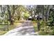 Long driveway to home surrounded by mature trees and lush landscaping at 3930 Griffin Ave, Lady Lake, FL 32159