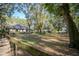 Exterior view of the property, showcasing a wooden fence, the expansive yard and wooded area beyond at 3930 Griffin Ave, Lady Lake, FL 32159