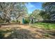 Quaint single-story home featuring a bright blue door and lush landscaping, nestled among mature trees and a grassy yard at 3930 Griffin Ave, Lady Lake, FL 32159