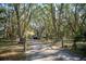 Long driveway leading to a one-story home shaded by mature trees at 3930 Griffin Ave, Lady Lake, FL 32159