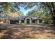 Charming single-story home with a lush, tree-filled front yard and a striking blue front door at 3930 Griffin Ave, Lady Lake, FL 32159