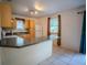 Kitchen features wood cabinets, breakfast bar, and access to an open dining area at 3930 Griffin Ave, Lady Lake, FL 32159
