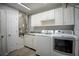 Laundry room features storage cabinets, counter space, utility sink, and modern front load machines at 3930 Griffin Ave, Lady Lake, FL 32159