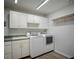Laundry room features storage cabinets above appliances, counter space, sink, and hanging rack at 3930 Griffin Ave, Lady Lake, FL 32159