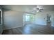 Large open living room with new floors, ceiling fan, and big windows providing ample natural light and nice views at 3930 Griffin Ave, Lady Lake, FL 32159