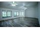 Open living room featuring wood-look flooring, ceiling fans, large windows, and plenty of natural light at 3930 Griffin Ave, Lady Lake, FL 32159