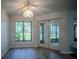 A living room has a large window with a backyard view and white framed french doors leading to lanai at 3930 Griffin Ave, Lady Lake, FL 32159