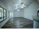 Spacious living room showcases wood-look floors, white trim, neutral paint, large windows and ceiling fans at 3930 Griffin Ave, Lady Lake, FL 32159