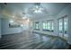 Large living room with wood-look flooring, ceiling fans, backyard views, and bar to kitchen space at 3930 Griffin Ave, Lady Lake, FL 32159