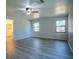 Main bedroom with new floors, ceiling fan, attached bathroom, and two windows providing natural light at 3930 Griffin Ave, Lady Lake, FL 32159