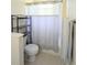 Cozy bathroom featuring a toilet, shower with a curtain and an organizer at 3969 Derby Glen Dr, Clermont, FL 34711