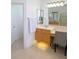Light-filled bathroom with vanity area, neutral tiling, and a large mirror reflects the airy space at 3969 Derby Glen Dr, Clermont, FL 34711