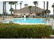 A community pool surrounded by palm trees and lush landscaping, providing a relaxing and picturesque amenity at 3969 Derby Glen Dr, Clermont, FL 34711