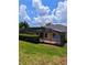 Exterior view of a home showcasing the screened-in patio with outdoor seating and lush landscaping at 3969 Derby Glen Dr, Clermont, FL 34711