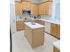 Kitchen with wooden cabinets, an island and stainless steel appliances, enhanced by a white tile backsplash at 3969 Derby Glen Dr, Clermont, FL 34711