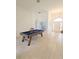 Spacious living room with light tile floors, billiard table, and stylish front door at 3969 Derby Glen Dr, Clermont, FL 34711