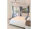 Bright main bedroom with a white bed, soft blue accents and a sliding door to the outdoor pool area at 3969 Derby Glen Dr, Clermont, FL 34711