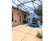 A screened patio with two lounge chairs, a blue umbrella, and green landscaping behind a house at 3969 Derby Glen Dr, Clermont, FL 34711