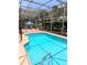 Sparkling swimming pool with screened-in enclosure and relaxing seating area at 3969 Derby Glen Dr, Clermont, FL 34711