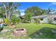 Expansive backyard with mature trees, a fire pit, and a well-maintained lawn at 410 E Gulley Ave, Oakland, FL 34760