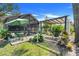 A charming backyard with a screened-in porch, patio table with umbrella and lush landscaping at 410 E Gulley Ave, Oakland, FL 34760