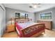 Cozy bedroom with hardwood floors, two windows, and a wooden bedframe and matching dressers at 410 E Gulley Ave, Oakland, FL 34760