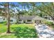 Single story home with beautiful green lawn, mature landscaping and cozy seating area on the front porch at 410 E Gulley Ave, Oakland, FL 34760
