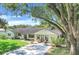 Charming single story home featuring a lush lawn, mature trees, and cozy front porch at 410 E Gulley Ave, Oakland, FL 34760