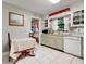 Charming kitchen featuring white tile flooring, matching appliances, and quaint decorative touches at 410 E Gulley Ave, Oakland, FL 34760