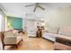 Bright living space featuring tile floors, neutral furniture, and a calming teal accent wall at 410 E Gulley Ave, Oakland, FL 34760