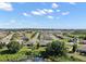 Scenic aerial view showcasing a peaceful neighborhood, mature trees, and a tranquil pond with a natural habitat at 440 Bellissimo Pl, Howey In The Hills, FL 34737