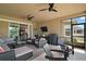 Relaxing covered patio featuring comfortable seating, outdoor grill, and ceiling fans for entertaining at 440 Bellissimo Pl, Howey In The Hills, FL 34737