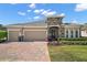 Charming single-story home featuring a two-car garage, stone accents, and well-manicured landscaping at 440 Bellissimo Pl, Howey In The Hills, FL 34737