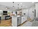 Bright and open kitchen with white cabinets, granite counters, a breakfast bar, and stainless appliances at 440 Bellissimo Pl, Howey In The Hills, FL 34737