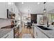 Modern kitchen with white cabinets, granite countertops, stainless steel appliances, and a cozy dining area at 440 Bellissimo Pl, Howey In The Hills, FL 34737