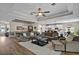 Expansive living room with tray ceilings, fan, and an open layout flowing into the dining and kitchen areas at 440 Bellissimo Pl, Howey In The Hills, FL 34737