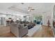 Bright living room featuring wood floors, tray ceilings, and seamless access to dining and kitchen areas at 440 Bellissimo Pl, Howey In The Hills, FL 34737