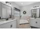 Bright main bathroom with double vanities, soaking tub and large windows at 440 Bellissimo Pl, Howey In The Hills, FL 34737
