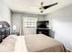 Relaxing bedroom featuring a ceiling fan, a window with curtains, dresser, and a cozy bed at 500 Newell Hill Rd # 113D, Leesburg, FL 34748