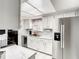 Modern kitchen with stainless steel appliances, white cabinets, and marble countertops at 500 Newell Hill Rd # 113D, Leesburg, FL 34748