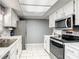 Charming kitchen with stainless steel appliances, white cabinets, marble countertops and tile floors at 500 Newell Hill Rd # 113D, Leesburg, FL 34748