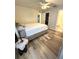 This is a bedroom with wood-look floors, a ceiling fan, a walk-in closet, and an ensuite bathroom at 5051 Nw 61St Ct, Ocala, FL 34482